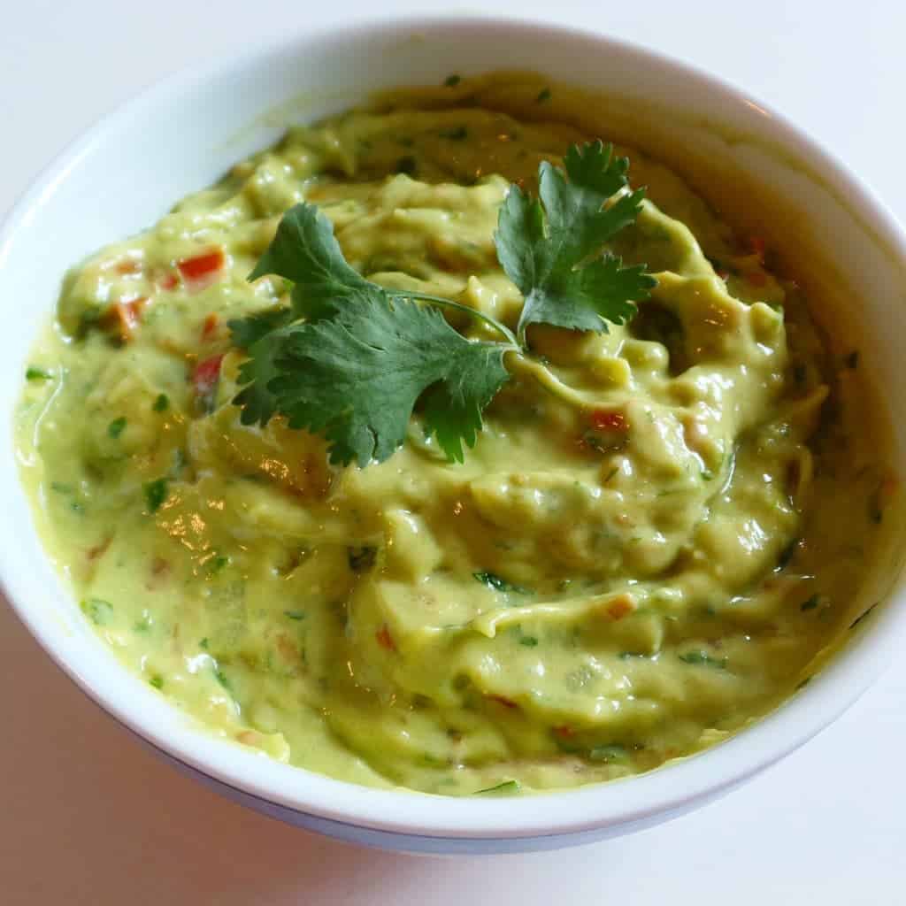 Mix 2 avocados, 1 tomato, 1 teaspoon salt, 3 tbs lime juice, 1 garlic clove, 1/4 cup onions, 1/2 cup of cilantro in Vitamix blender for 20 sec.