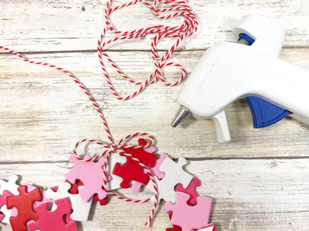 Upcycle your old puzzles with this lovely DIY. Here's how to make a heart wreath with puzzle pieces to decorate your home for Valentine's Day!