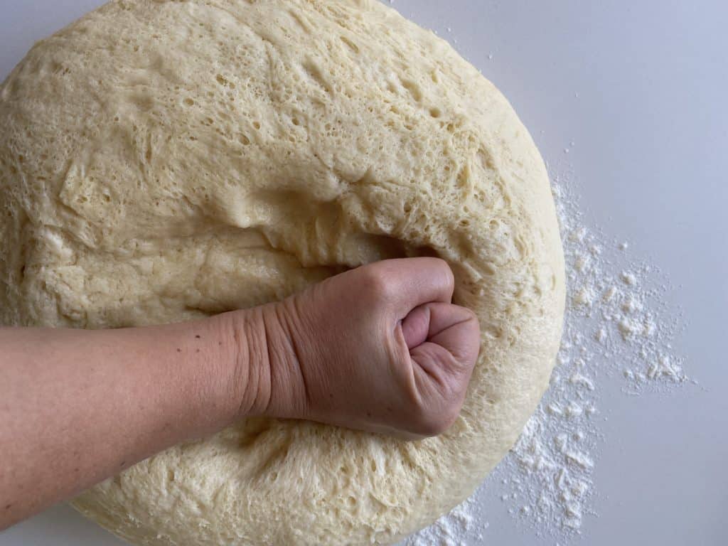 Punching challah bread dough