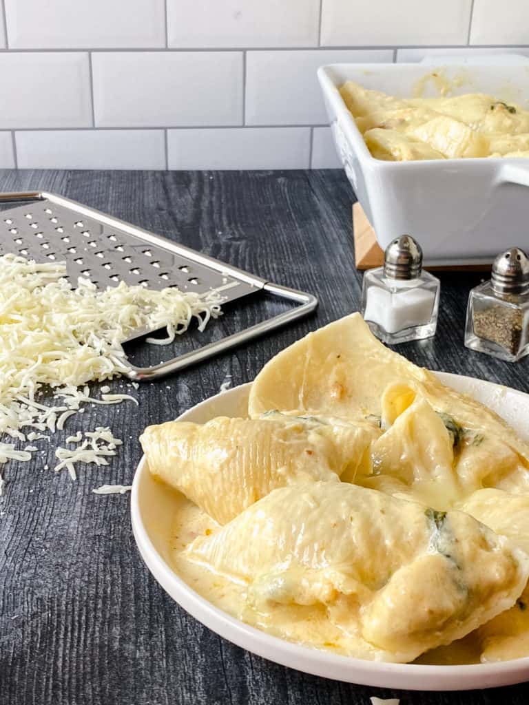 These delicious cheesy chicken stuffed pasta shells are tasty, filling and even sneak in some spinach. Perfect for dinner!