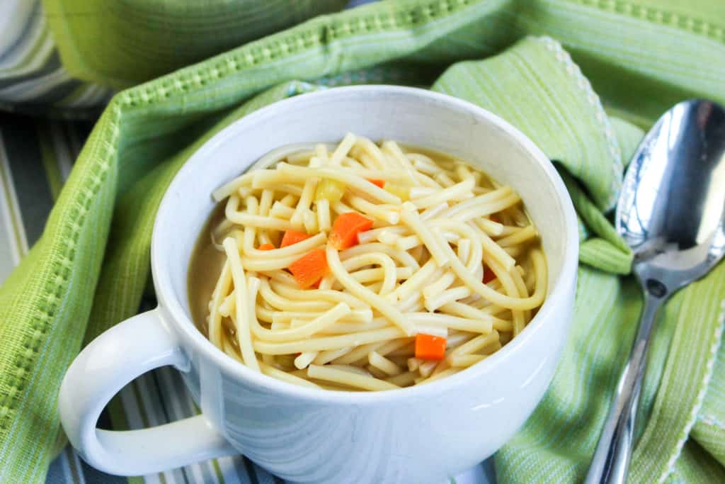 Close up image of double noodle soup in a white mug