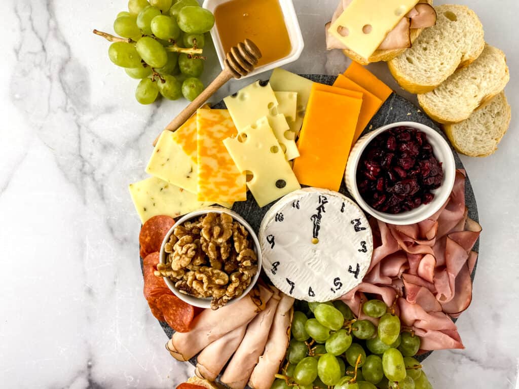 Learn how to make an exquisite New Year's Eve charcuterie board that promises to tantalize the taste buds with your favorite cheeses, meats and fruit.