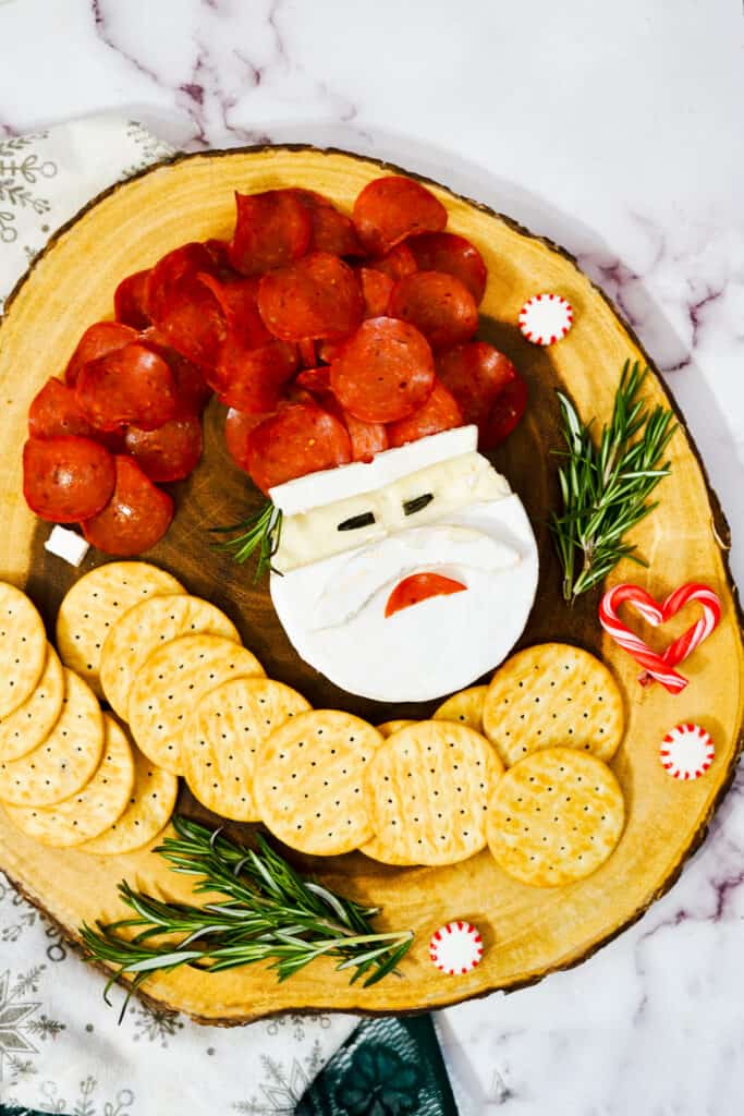 This adorable Santa Brie board will become one of your favorite holiday appetizers. In just a few minutes make a festive Santa Claus Brie board that will become the star of your Christmas party.