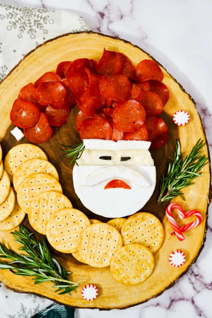 Adorable santa Brie board with crackers and rosemary twigs