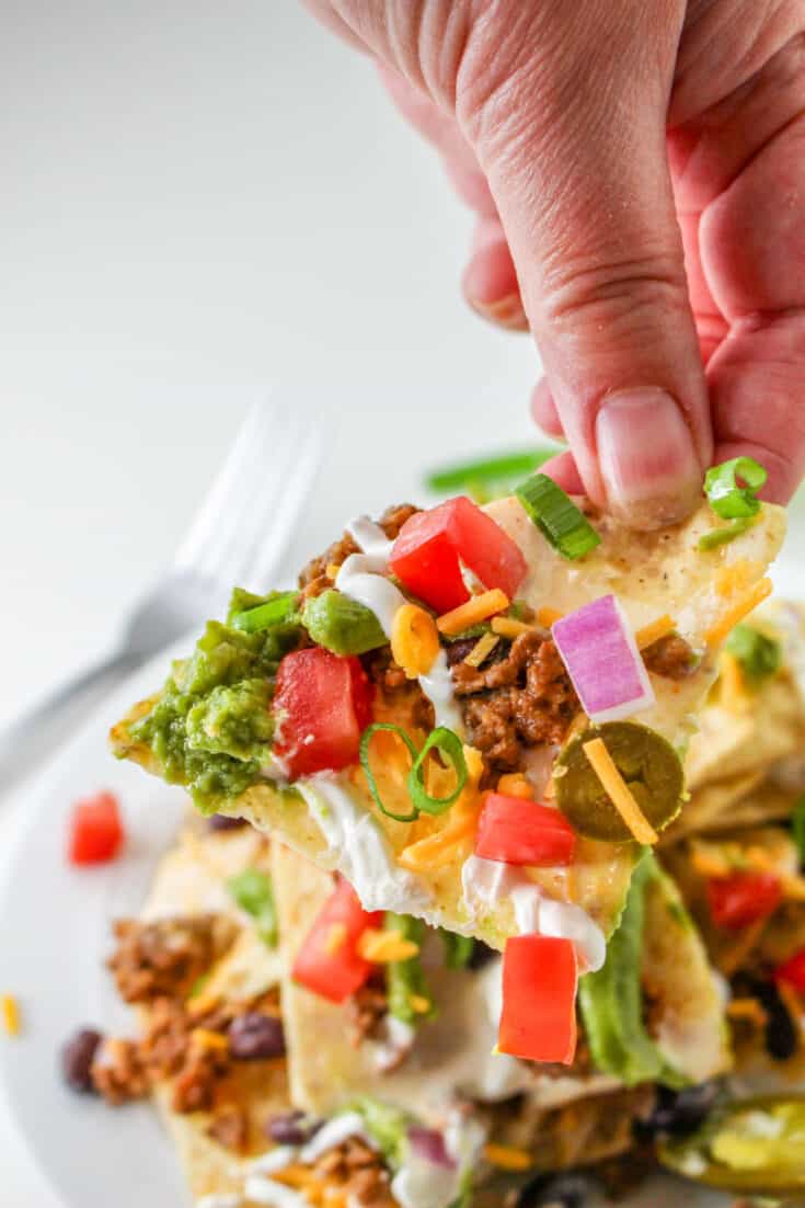 This Trash Can Nachos recipe is a true game day showstopper with its dramatic presentation and delectable layers of flavors. Everybody loves the layers of crunchy tortilla chips, savory taco meat, creamy white queso dip, and all the fixings.