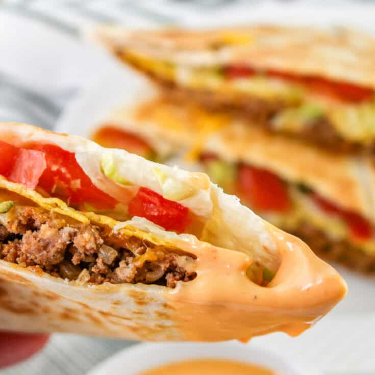 This ultimate cheeseburger crunch wrap recipe is so satisfying and easy to make! The secret ingredient is a crispy tostada shell strategically placed in the middle of the wrap so it is extra crunchy every time you bite into your burger.